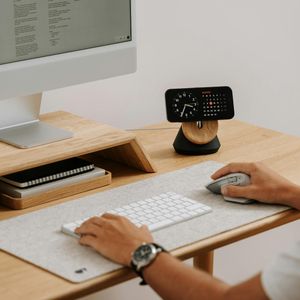 Minimalist wooden office accessories on a light ivory desk.